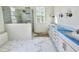 A luxurious bathroom featuring a glass-enclosed shower, double vanity with marble counters, and stylish fixtures at 1721 Burnette Garden Path, Raleigh, NC 27612