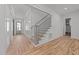 Bright entryway with hardwood floors, a staircase, and a view of the front door at 1721 Burnette Garden Path, Raleigh, NC 27612