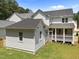 Rear exterior view of home with an attached building, screened-in porch and lush lawn at 1721 Burnette Garden Path, Raleigh, NC 27612
