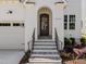 Inviting front entrance with an arched doorway, stone steps, and wrought iron railings at 1721 Burnette Garden Path, Raleigh, NC 27612
