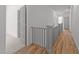 Hallway with hardwood floors and a gray railing at 1721 Burnette Garden Path, Raleigh, NC 27612