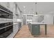 Open concept kitchen with a large island, stainless steel appliances, and hardwood floors at 1721 Burnette Garden Path, Raleigh, NC 27612