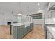 Modern kitchen features an island with farmhouse sink and stainless steel appliances at 1721 Burnette Garden Path, Raleigh, NC 27612