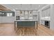 Modern kitchen with gray cabinets, a large island, stainless steel appliances, and hardwood floors at 1721 Burnette Garden Path, Raleigh, NC 27612