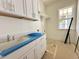 Well-lit laundry area features counter space, cabinetry for organized storage, and a sink for added convenience at 1721 Burnette Garden Path, Raleigh, NC 27612