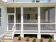 Rear view of screened porch with stairs leading to backyard and lush landscaping at 1721 Burnette Garden Path, Raleigh, NC 27612