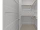 A well-organized walk-in closet with custom shelving and soft, neutral-colored carpeting to maximize storage at 1721 Burnette Garden Path, Raleigh, NC 27612