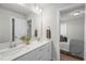 Bathroom featuring a double sink vanity with modern fixtures, a large mirror, and a glimpse into a bedroom at 211 Pond View Ct # 5, Fuquay Varina, NC 27526