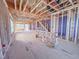 A spacious, unfinished interior reveals the framing of a new construction home with stairs and window placement at 211 Pond View Ct # 5, Fuquay Varina, NC 27526