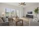 Bright living room filled with natural light, showcasing neutral furniture, ceiling fan, and a decorative entertainment center at 211 Pond View Ct # 5, Fuquay Varina, NC 27526