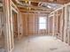 An unfinished room with wood framing, large windows, and exposed plumbing, ready for customization and personalization at 211 Pond View Ct # 5, Fuquay Varina, NC 27526