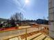 A beautiful exterior view of a new construction home shows the community, lake, and trees from the unfinished deck at 211 Pond View Ct # 5, Fuquay Varina, NC 27526