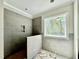 Modern bathroom with gray tiled shower and a window with a wooded view at 2624 Silver Gate Ct, Wake Forest, NC 27587