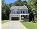 Two-story home features a gray facade, black shutters, and an attached, open garage, plus a front porch at 2624 Silver Gate Ct, Wake Forest, NC 27587