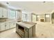 Spacious kitchen features white cabinets, a gray kitchen island, and a fireplace at 2624 Silver Gate Ct, Wake Forest, NC 27587