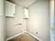 A compact laundry room showcases utility hookups and offers space-saving storage with white cabinets at 2624 Silver Gate Ct, Wake Forest, NC 27587