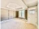 Living room with decorative paneled walls, large window, tray ceiling, and unfinished floors at 2624 Silver Gate Ct, Wake Forest, NC 27587