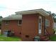 A brick home with a white door, steps, and a small patch of green grass is seen at 608 N Ellis Ave, Dunn, NC 28334