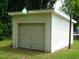 A white garage with a light over the door is surrounded by foliage at 608 N Ellis Ave, Dunn, NC 28334