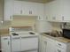 This kitchen is equipped with classic white cabinets, a stove and sink at 608 N Ellis Ave, Dunn, NC 28334