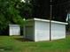 A view of a white detached garage and shed on a grassy lawn with trees at 608 N Ellis Ave, Dunn, NC 28334