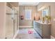 Well-lit bathroom with gray cabinets, marble countertops, and a glass shower with decorative tile at 3177 Armeria Dr, Apex, NC 27502