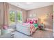 Charming bedroom featuring a bed with a white studded headboard, windows and a desk at 3177 Armeria Dr, Apex, NC 27502