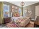Cozy bedroom with neutral colors, decorative chandelier, and large windows at 3177 Armeria Dr, Apex, NC 27502