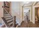 Hallway with wood floors and staircase leading to a living area with fireplace and furniture at 3177 Armeria Dr, Apex, NC 27502