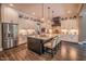 Spacious open kitchen featuring a large island with seating, stainless steel appliances, and modern lighting at 3177 Armeria Dr, Apex, NC 27502