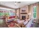 Bright living room with fireplace, ceiling fan, and large windows overlooking the backyard at 3177 Armeria Dr, Apex, NC 27502