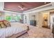 Bright main bedroom with tray ceiling, plush carpet, upholstered bed, and en suite bathroom at 3177 Armeria Dr, Apex, NC 27502