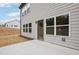 New construction house back exterior featuring a concrete patio, light gray siding, and newly graded lawn at 3301 Oakfields Rd # 2, New Hill, NC 27562