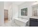 Bright bathroom showcasing a modern soaking tub beneath a window offering views of the outdoors and stylish patterned tile flooring at 3301 Oakfields Rd # 2, New Hill, NC 27562