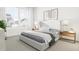 Spacious bedroom with a light-grey upholstered bed, two nightstands and large windows with a view at 4043 Elk Creek Ln # 15, Raleigh, NC 27612