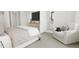 Bright bedroom with a light-grey upholstered bed, a white armchair and a built-in TV stand at 4043 Elk Creek Ln # 15, Raleigh, NC 27612