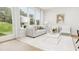 Bright living room with white couch, two armchairs, and large windows overlooking a grassy area at 4043 Elk Creek Ln # 15, Raleigh, NC 27612