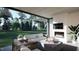 Covered outdoor patio with a cozy fireplace, comfortable seating, and a view of the green outdoors at 60 Chestnut Oak Dr, Youngsville, NC 27596