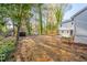 A spacious, tree-lined backyard with a small shed and a BBQ pit at 2804 Edgewood Ave, Burlington, NC 27215