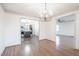 Dining area with hardwood floors, modern chandelier, and view to the kitchen at 2804 Edgewood Ave, Burlington, NC 27215