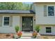 An inviting front entrance with a stylish door, potted plants, and freshly painted brick at 2804 Edgewood Ave, Burlington, NC 27215