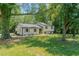 Lovely home with lush green lawn, flowering shrubs, and a beautiful, tree-lined front yard at 2804 Edgewood Ave, Burlington, NC 27215