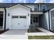 Charming townhome with a white garage door, inviting entrance, and well-maintained landscaping at 478 Traditions Grande Blvd # 32, Wake Forest, NC 27587