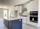 Eat-in kitchen showcasing a large island, white cabinets, stainless appliances, and marble backsplash at 478 Traditions Grande Blvd # 32, Wake Forest, NC 27587