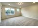 A bright, carpeted bedroom with two large windows overlooking the outdoor scenery at 482 Traditions Grande Blvd # 30, Wake Forest, NC 27587