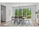 Bright dining room features a wood table, black chairs, modern lighting, and scenic backyard views at 6420 Tanner Oak Ln, Raleigh, NC 27613