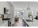 Open-concept kitchen showcases white cabinets, stainless steel appliances, and an island overlooking the living space at 6420 Tanner Oak Ln, Raleigh, NC 27613