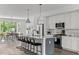 Modern kitchen island with barstools, stainless steel appliances, and stylish fixtures flowing into the dining area at 6420 Tanner Oak Ln, Raleigh, NC 27613