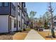 Exterior view of newly built townhouses lined along a sidewalk in a modern planned community at 6420 Tanner Oak Ln, Raleigh, NC 27613