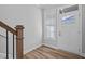 Bright entryway with wood-look flooring, white door with glass, white walls, and wood banister at 703 Jamescroft Way, Rolesville, NC 27587